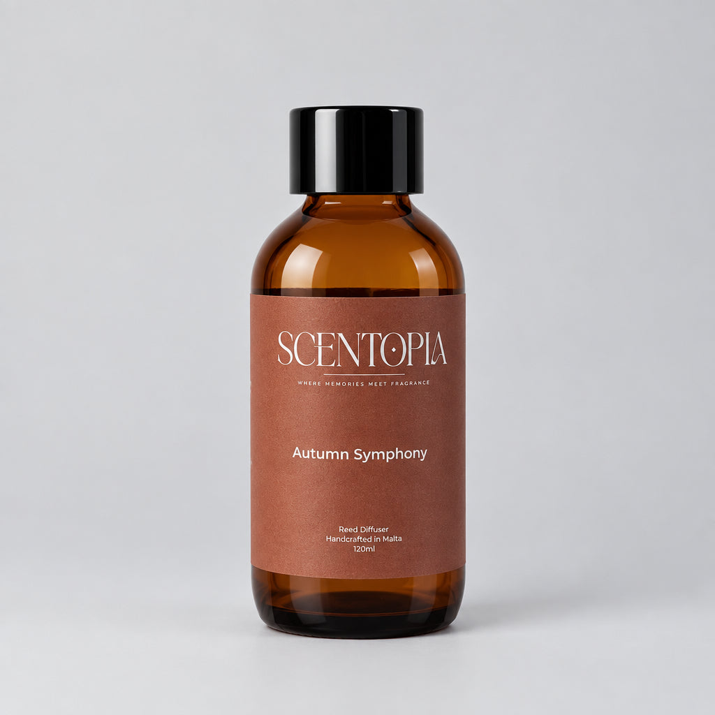 An amber glass bottle of Scentopia 'Autumn Symphony' room diffuser oil with a black cap, resting on a wooden surface against a neutral beige background.